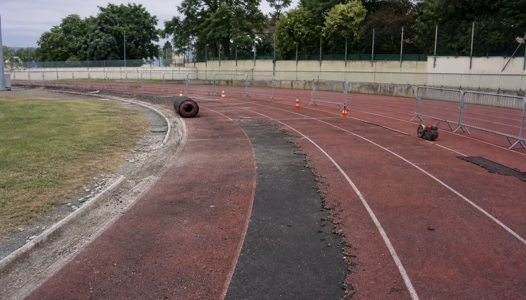 Travaux de rénovation sur une piste d’athlétisme dans un parc des sports