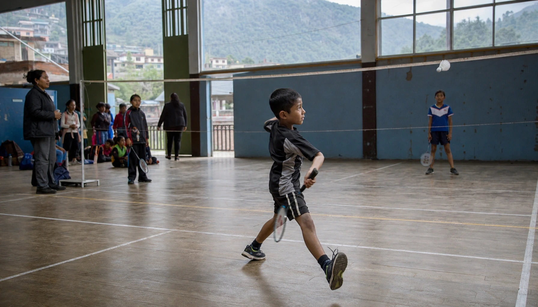 Enfants découvrant le badminton dans un gymnase situé en zone de montagne